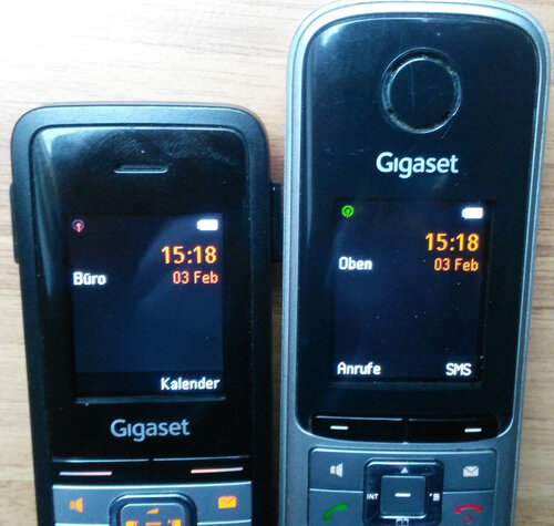 Zwei Gigaset-Telefone, eins mit grau-rotem und eins mit grünem Icon